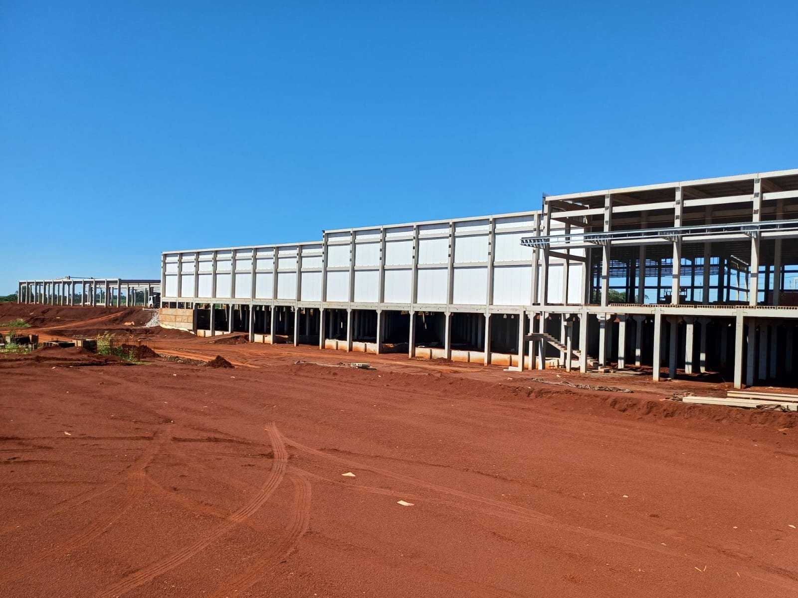 Canteiro de obras com perfis e estacas empilhados